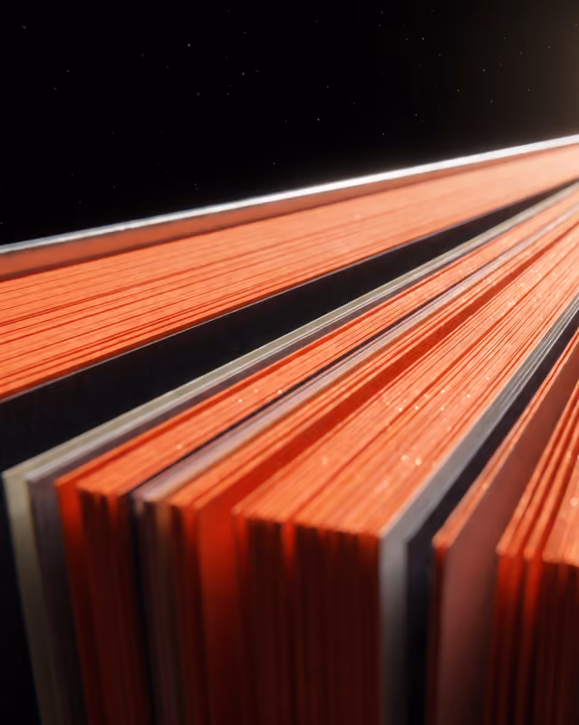 Nahaufnahme der orangefarbenen Seiten eines aufgeschlagenen Buches vor schwarzem Hintergrund.