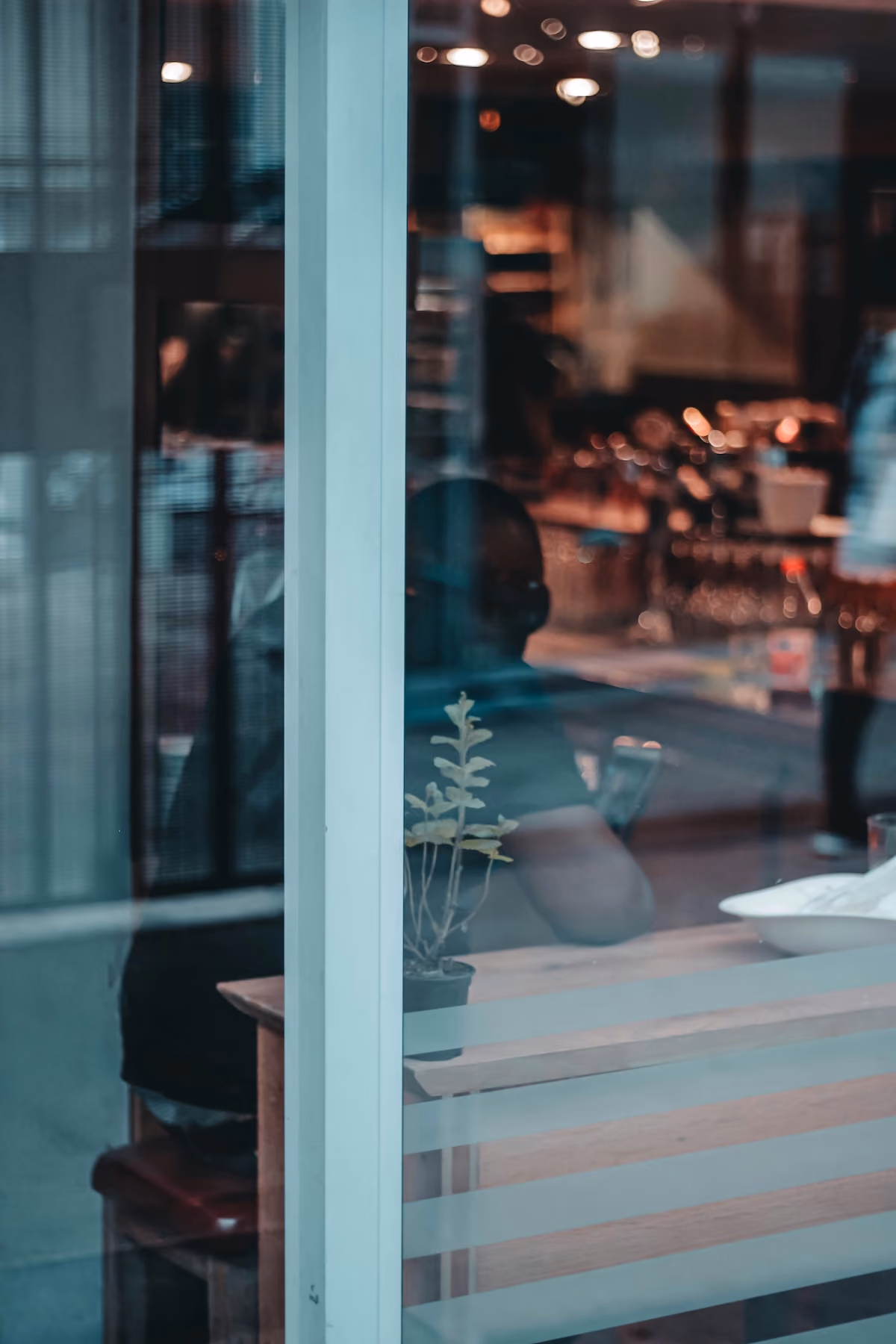 Cafe interior reflected in glass at dusk