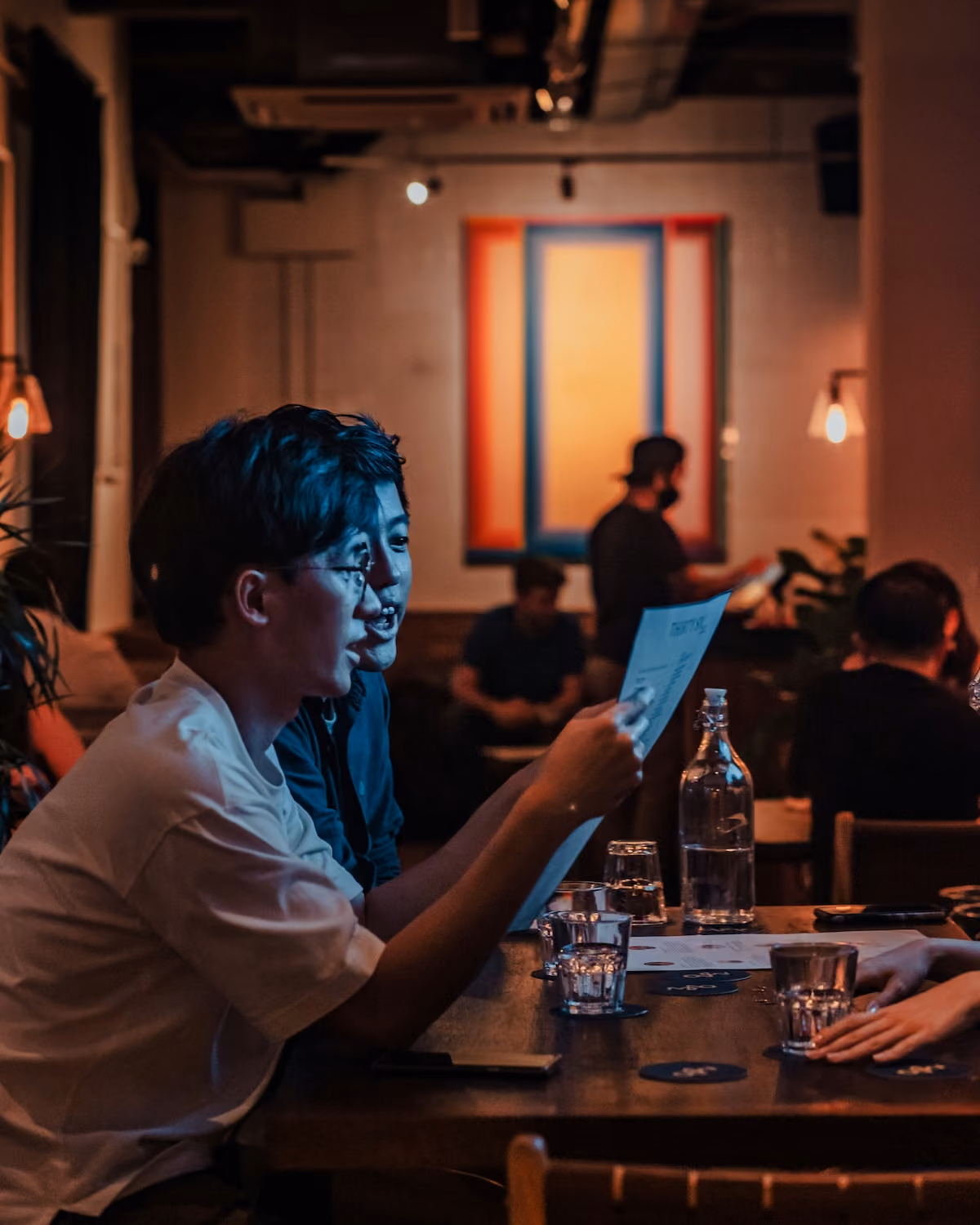 Man reading a document at a bar in evening light
