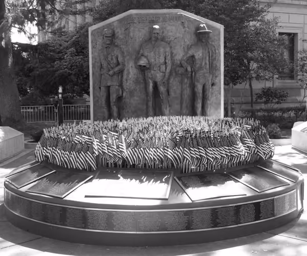 War memorial with soldier statues surrounding a wreath display