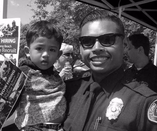 Police officer posing with a child at a community outreach event