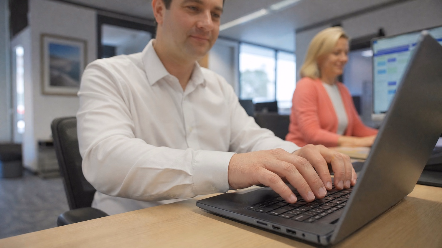 Mans hands typing email on laptop, using Copilot 60 chars