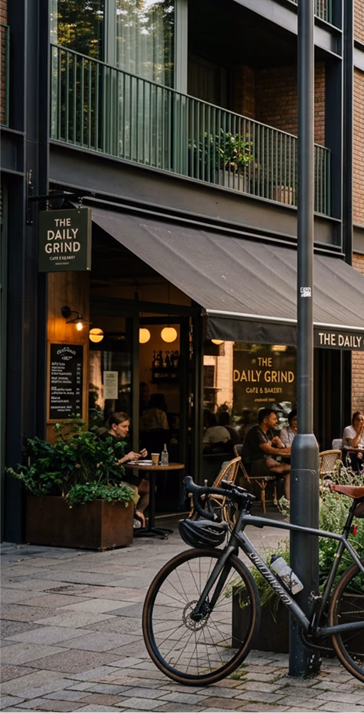 Outdoor view of The Daily Grind café with customers dining and a bicycle parked nearby.