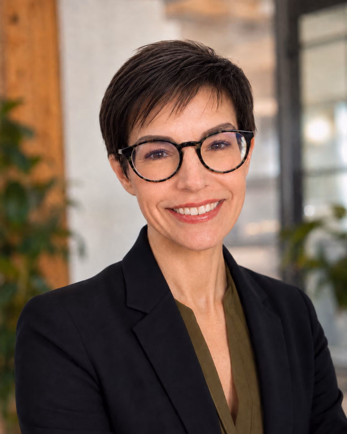 Professional headshot of an UrbanKind planning consultant wearing glasses and a dark blazer.