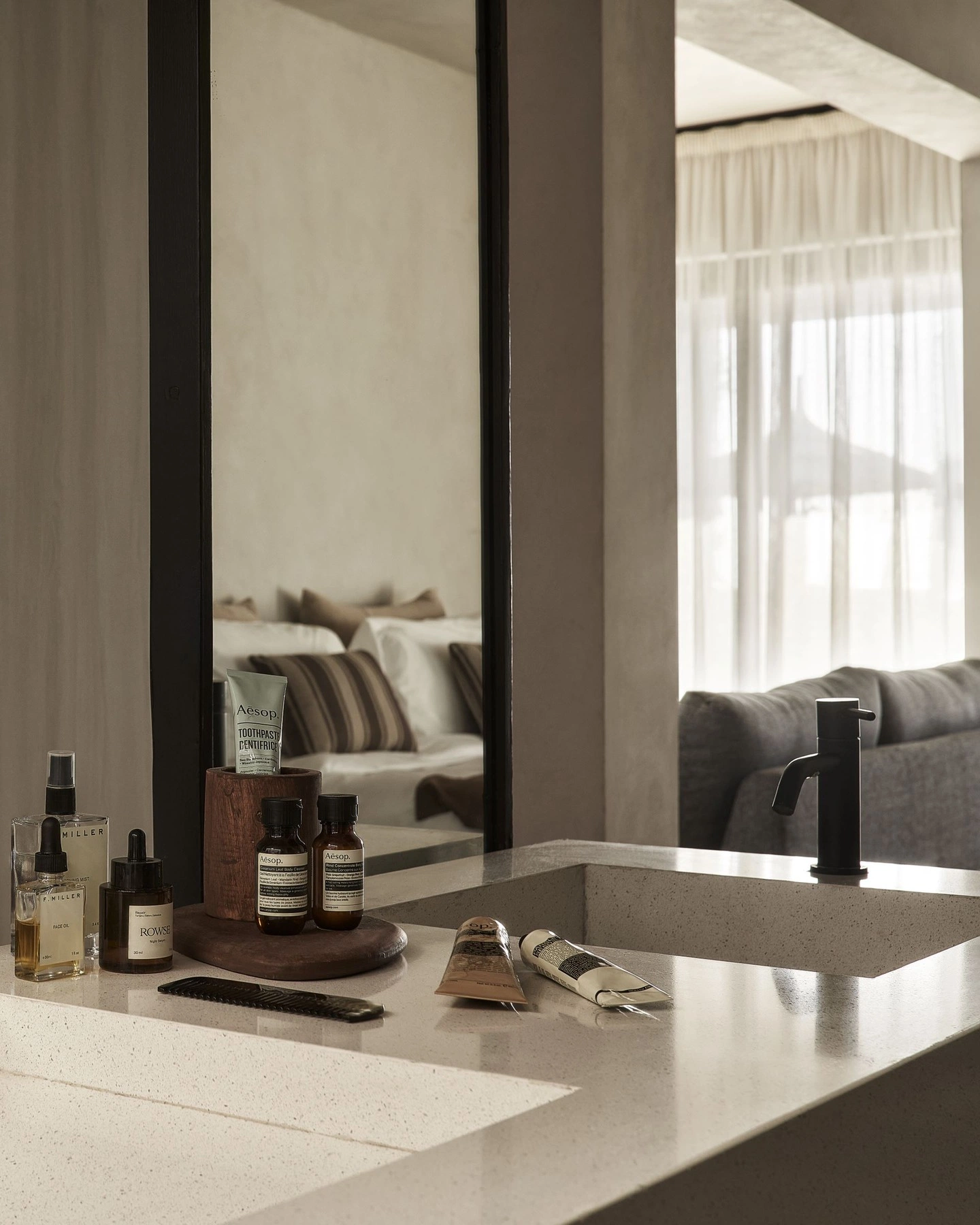 Vanité de salle de bain en quartz avec robinet noir et produits de soin dans une suite de Rive Lac Tremblant