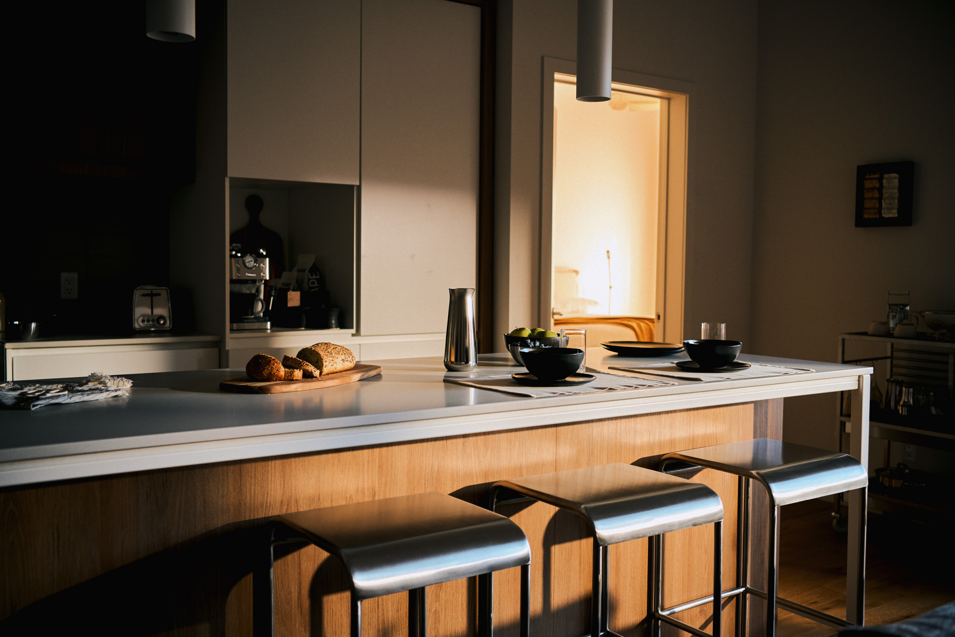 Kitchen island with stainless steel stools in warm evening light at a Rive Lac Tremblant condo