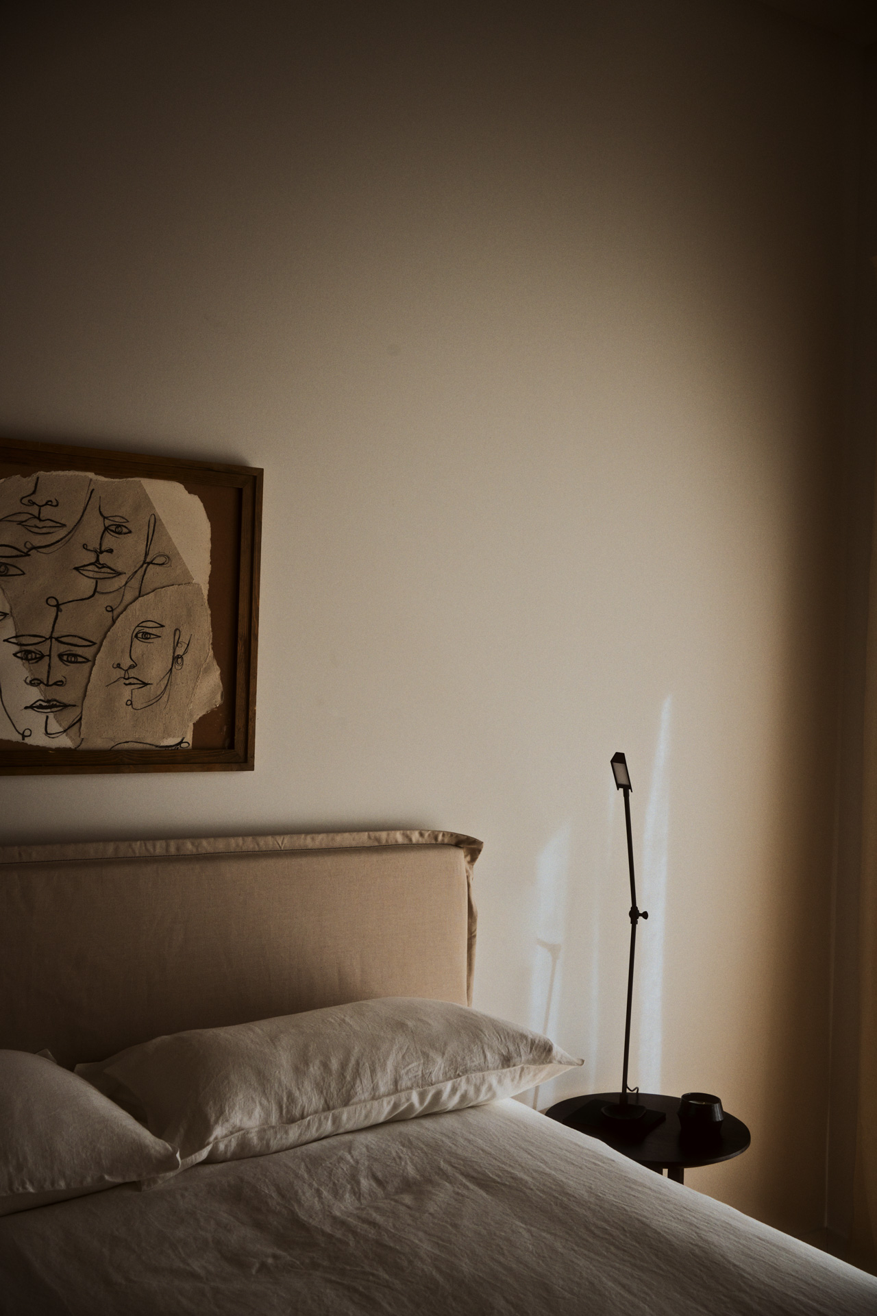 Calm bedroom in a Rive Lac Tremblant condo with linen bedding and a framed line-drawing artwork
