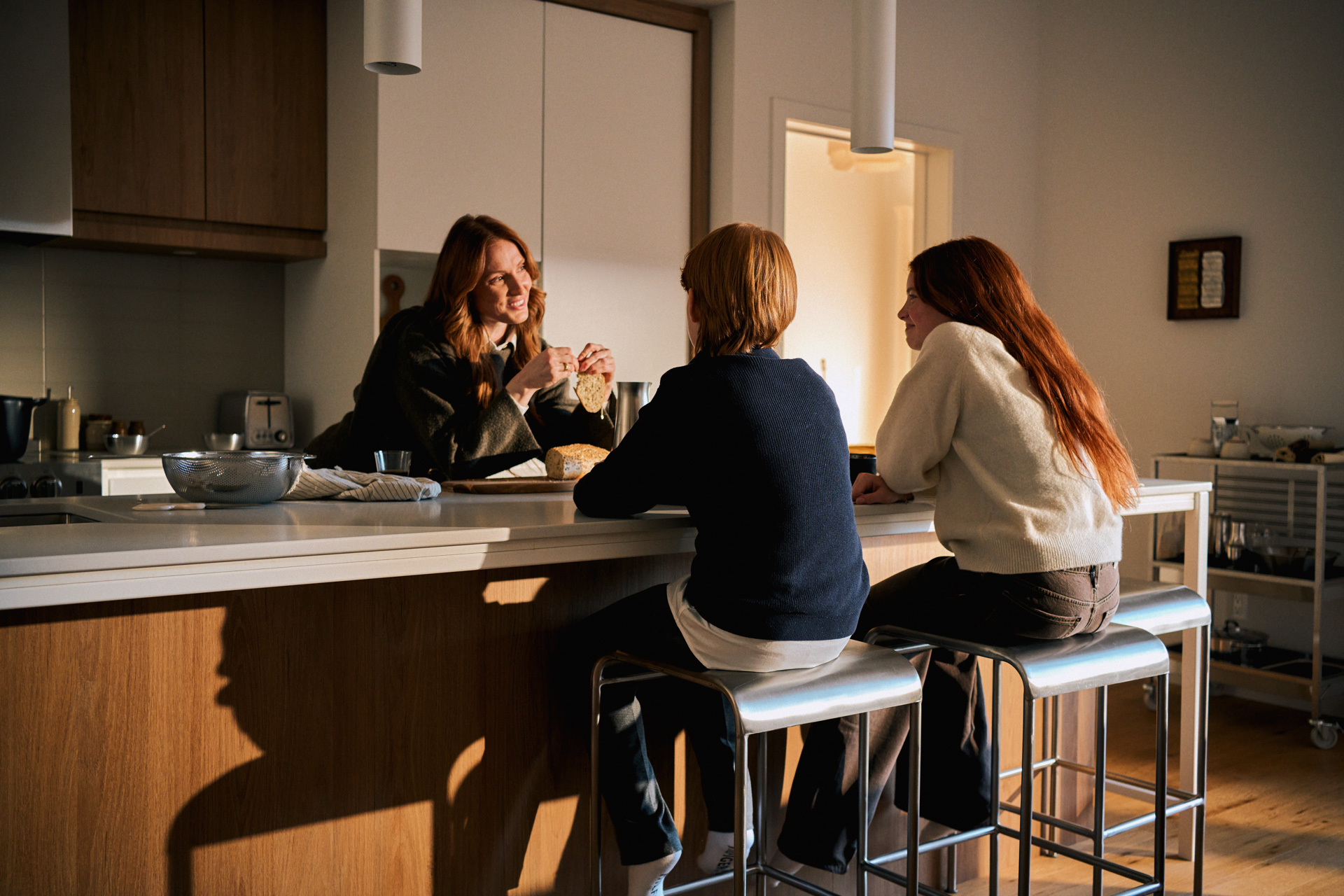 Family chatting around the kitchen island of a sunlit Rive Lac Tremblant condo