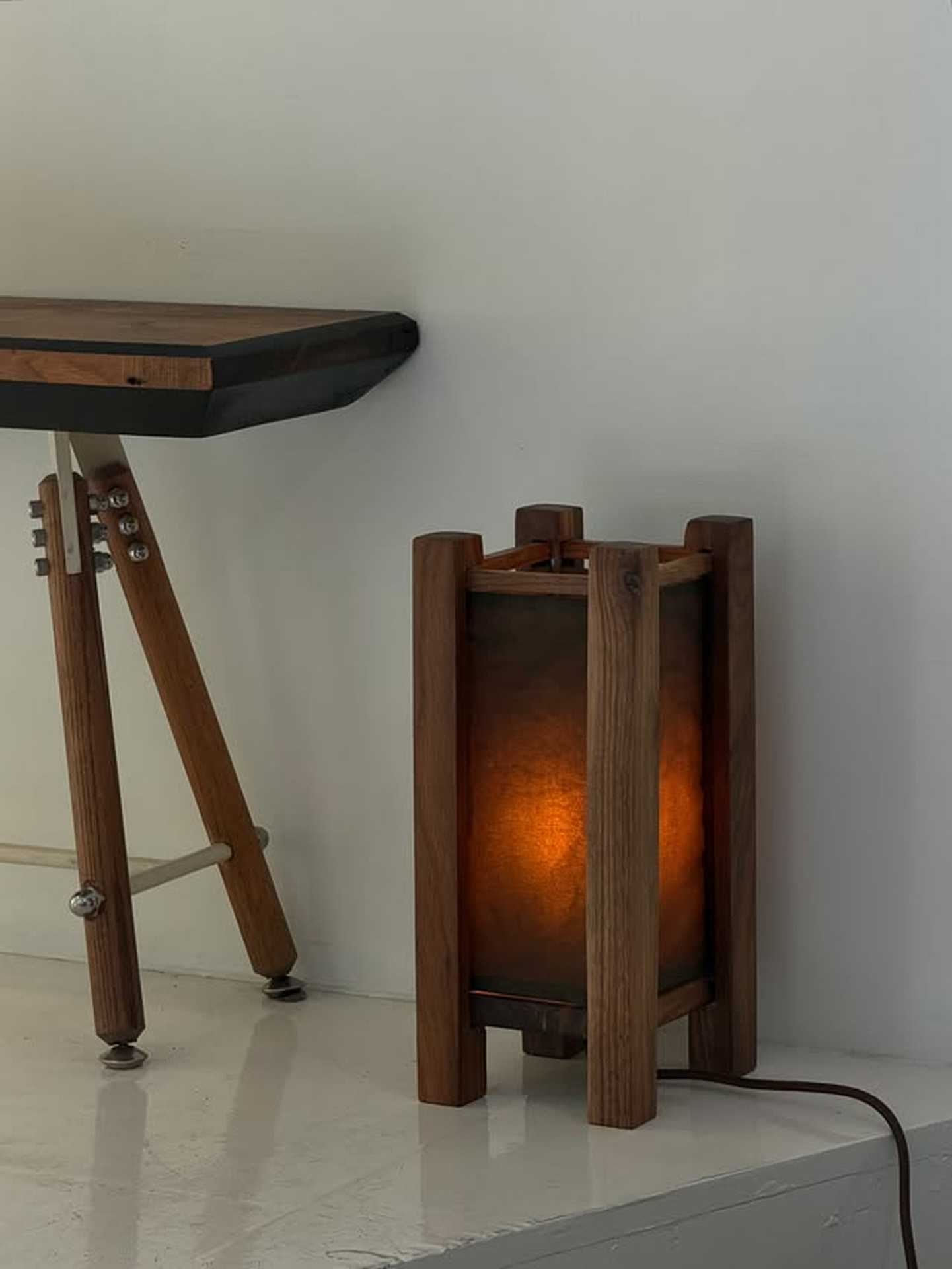 Gros plan d'une lampe lanterne en noyer à l'abat-jour ambré illuminé