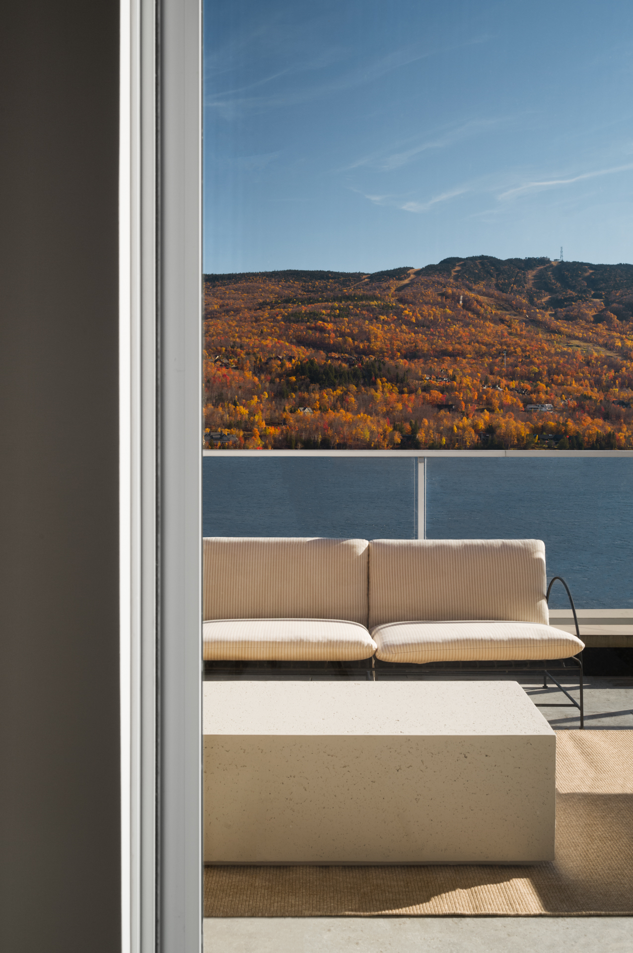 Terrasse au bord du lac à Rive Lac Tremblant encadrant les pentes du mont Tremblant aux couleurs de l'automne