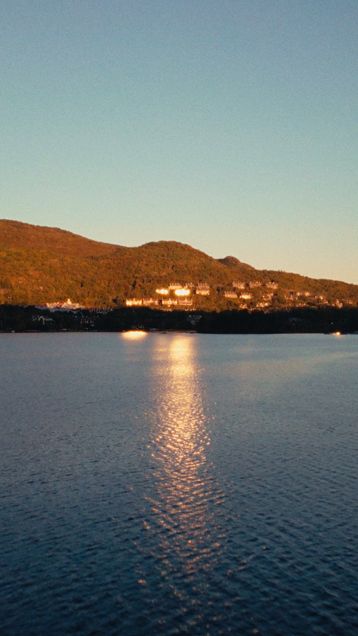 Coucher de soleil se reflétant sur le lac Tremblant au pied de la montagne, vu de Rive Lac Tremblant