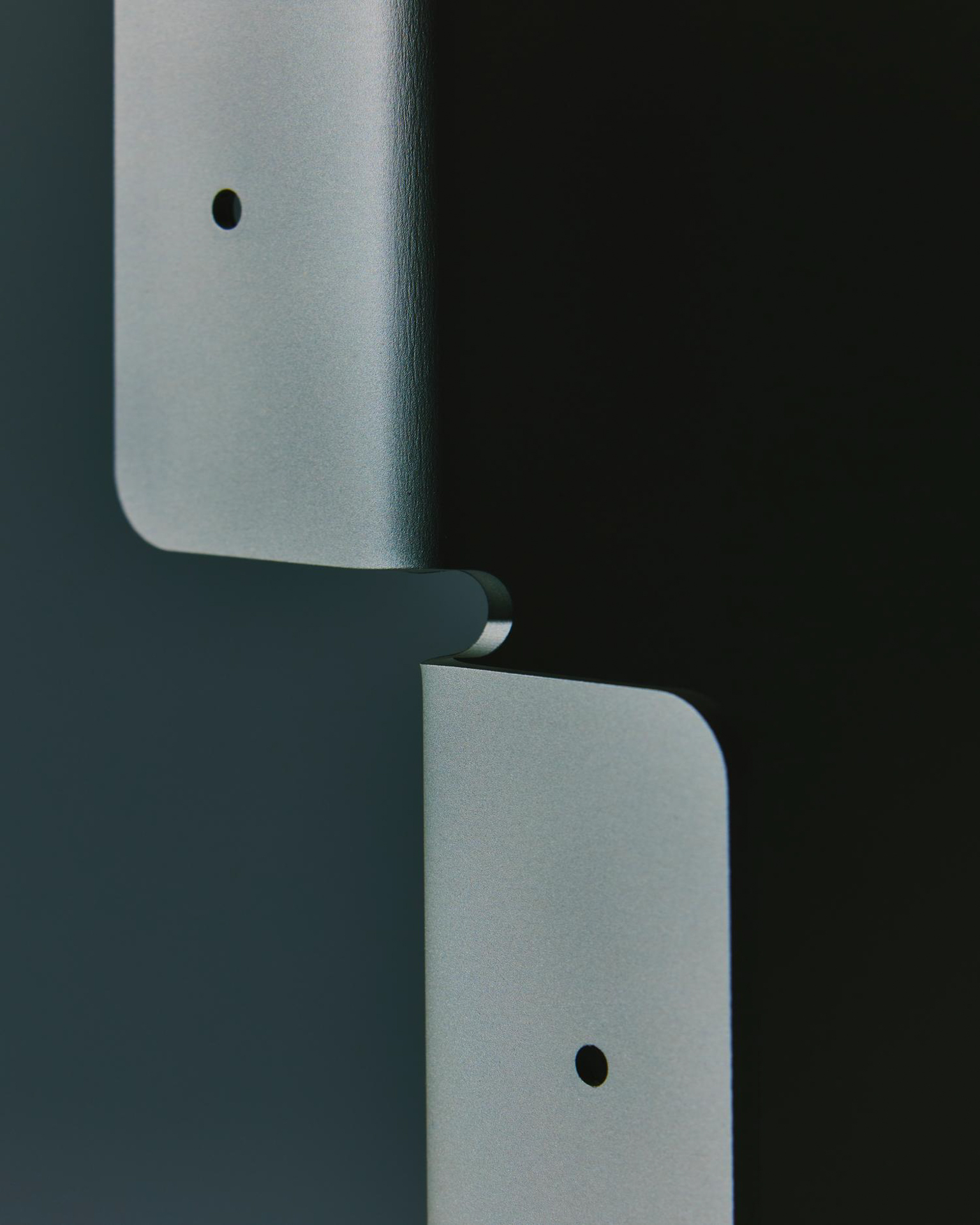 Detail of interlocking powder-coated metal shelf brackets by LESORR