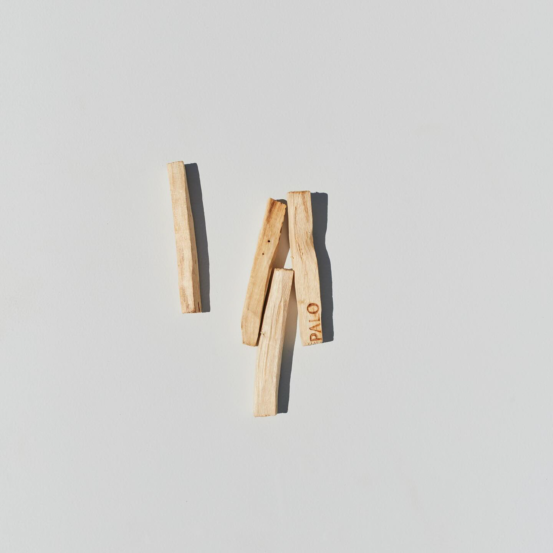Palo palo santo sticks laid out on a light background