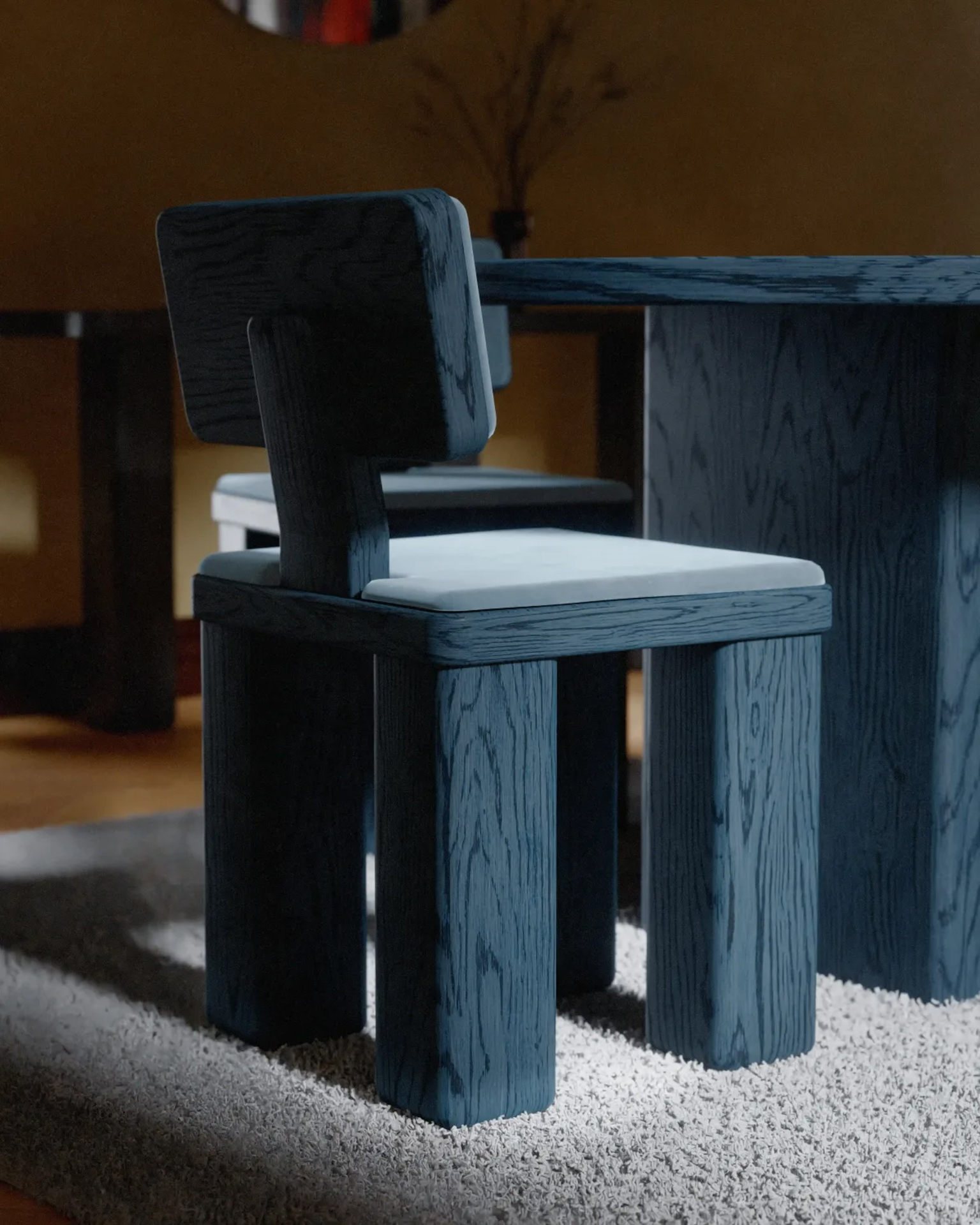 Close-up of a sculptural blue oak dining chair by Studio Super Sunday on a textured rug