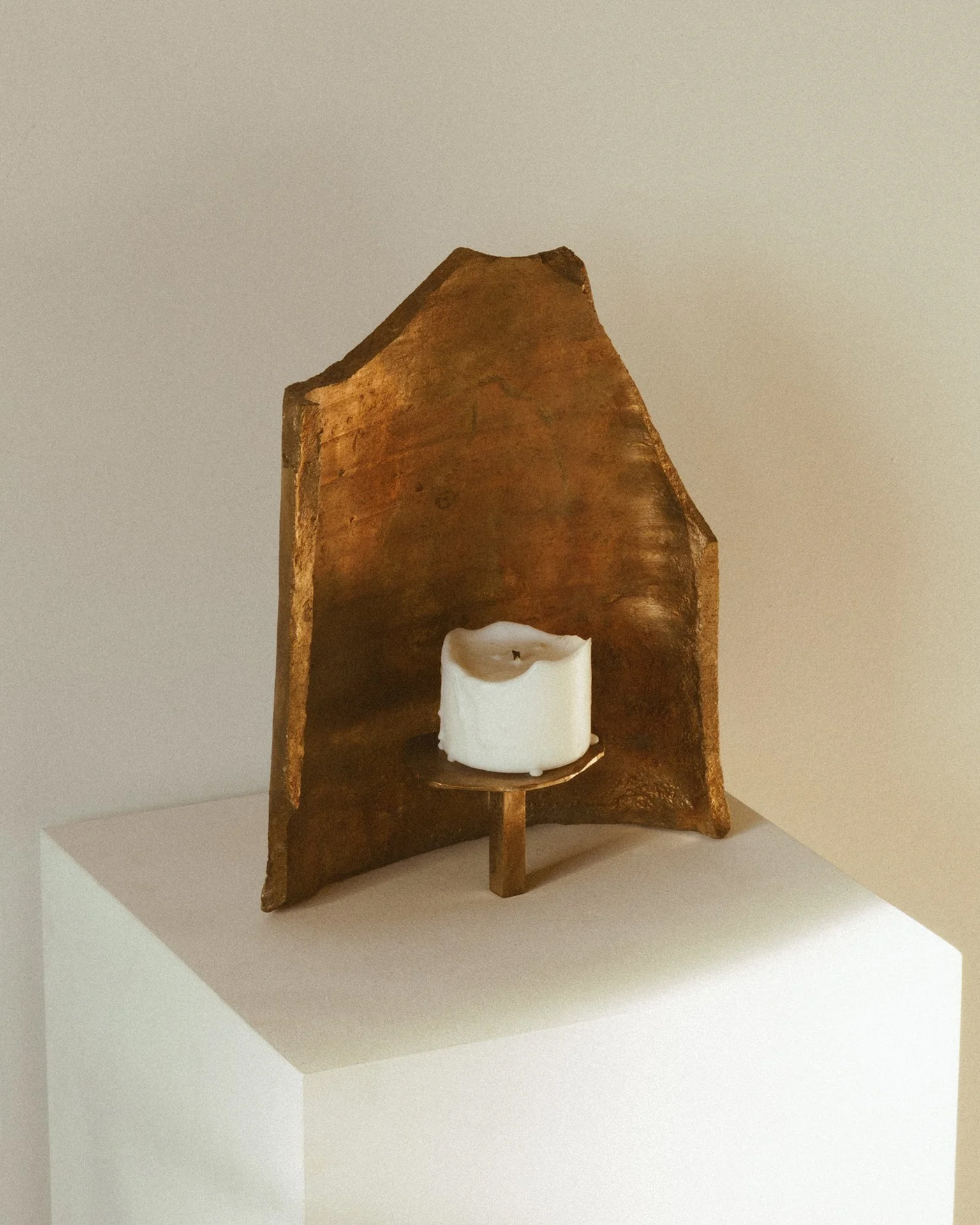 Cast bronze candle holder sculpture by Jeremy Le Chatelier on a white plinth, featured at Rive Lac Tremblant