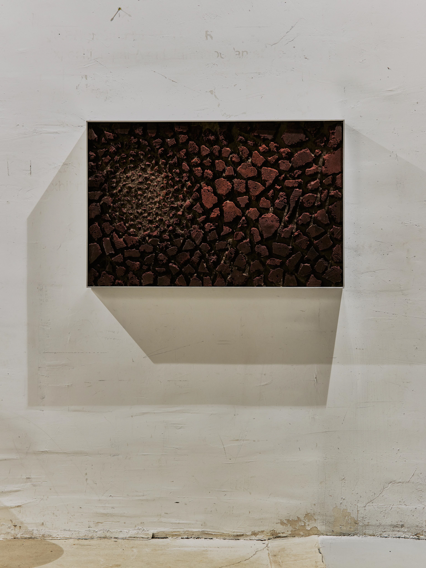 Framed textured relief artwork in terracotta tones by Edith, local art showcased at Rive Lac Tremblant