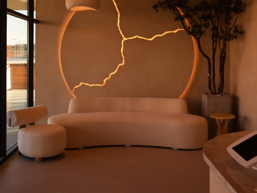 Curved lounge sofa beneath a golden kintsugi arc at Kintsugi Yoga in Las Vegas