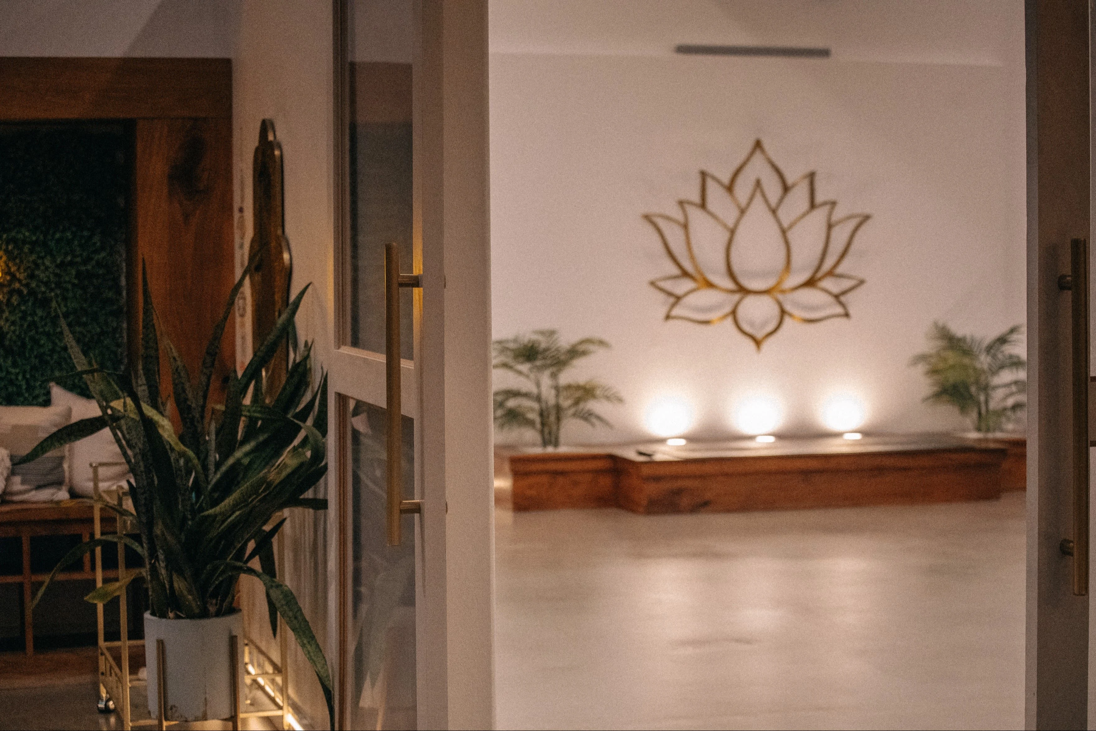 Candlelit meditation altar with a golden lotus emblem and potted plants at Kintsugi Yoga in Las Vegas