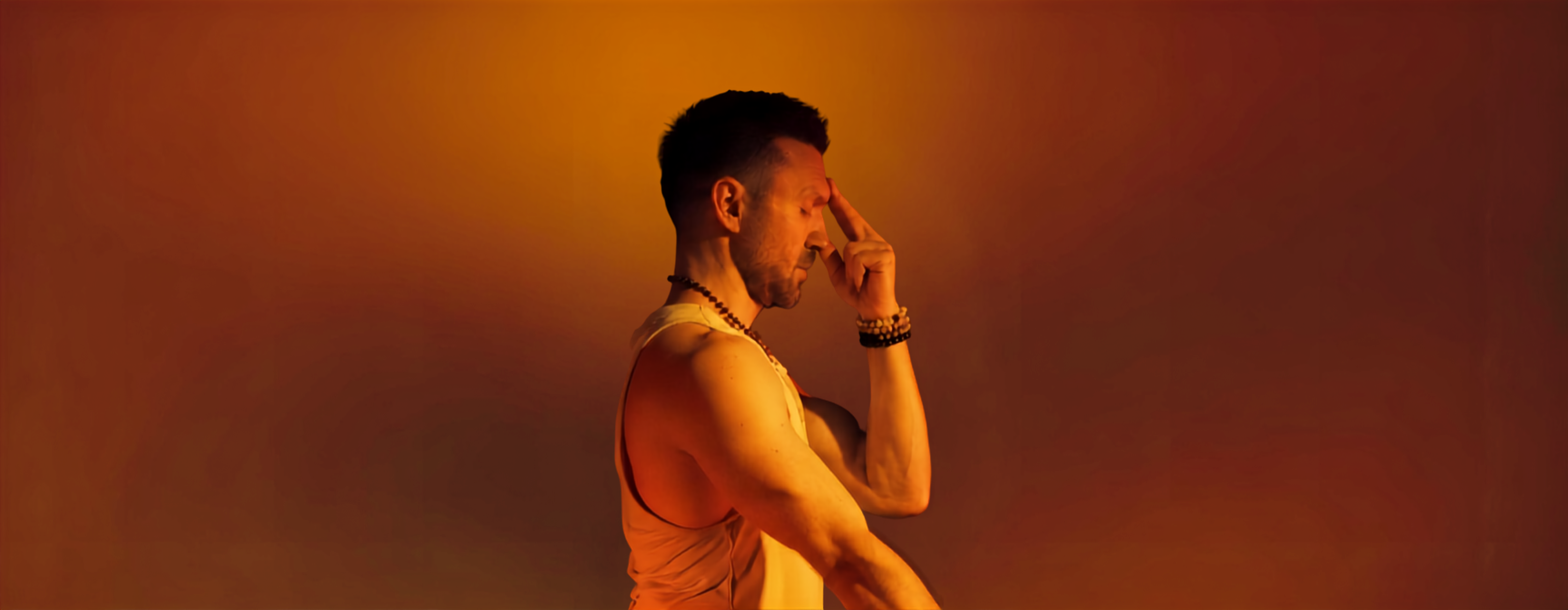 A person practicing pranayama breathing with fingers to the nose in warm light
