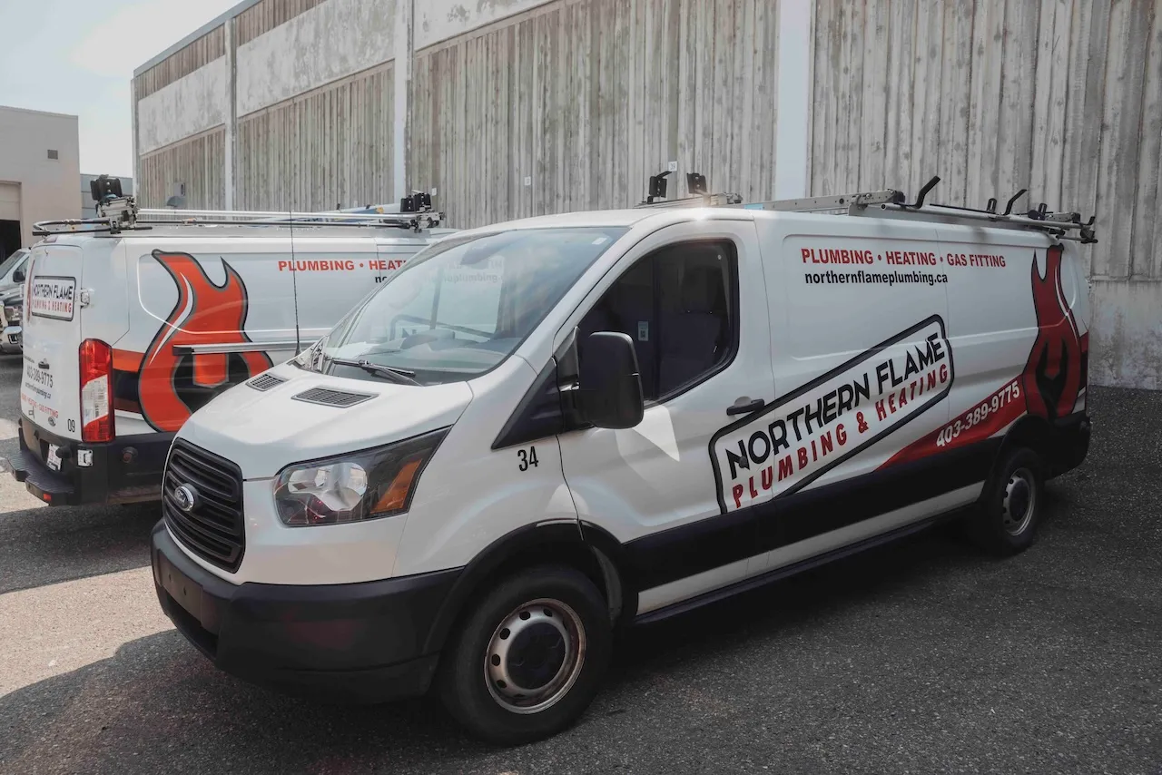 Two branded Northern Flame Ford Transit service vans parked outside the shop