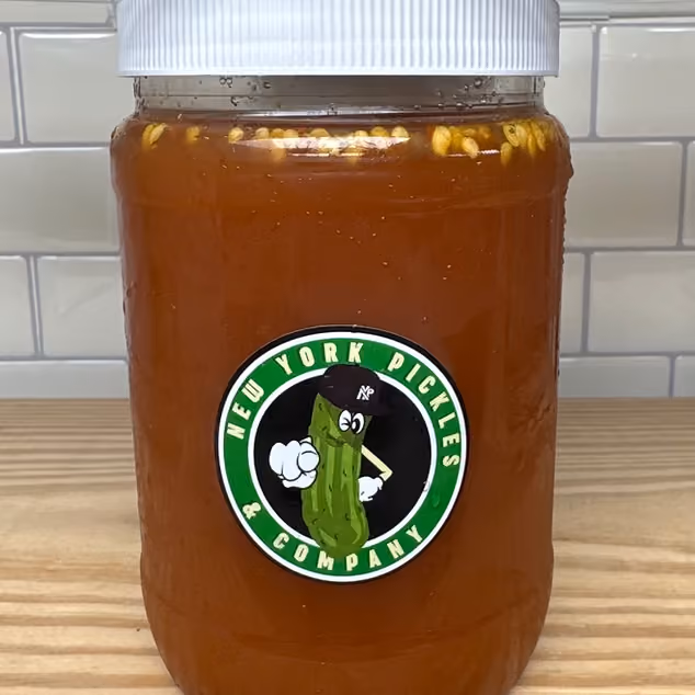 Jar of spicy pickles with seeds inside and New York Pickles & Company logo on front.