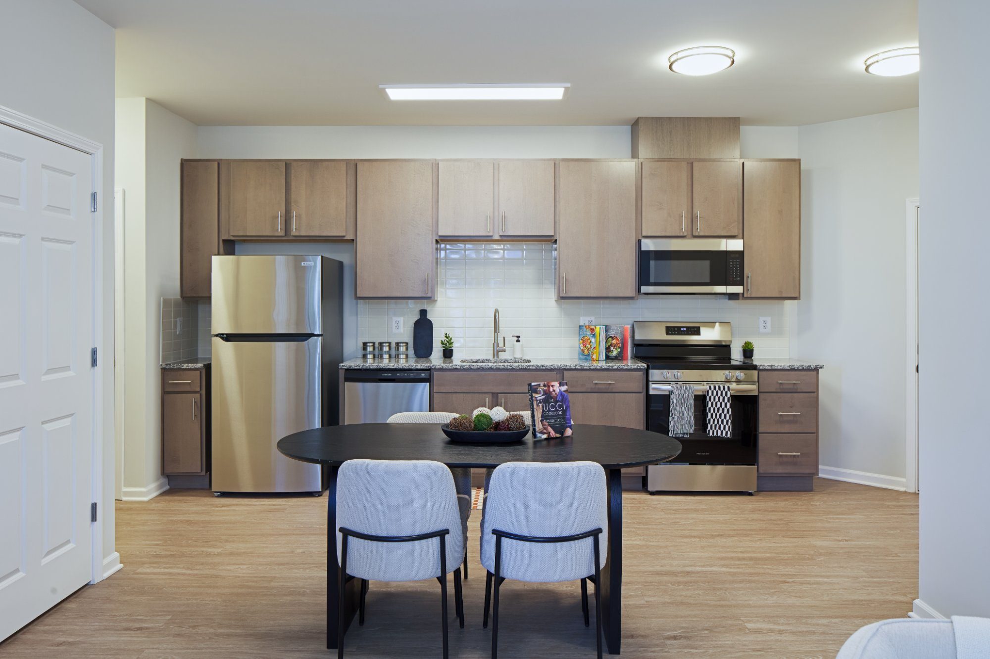 Kitchen in a brand-new Joyfield apartment with stainless appliances and granite counters