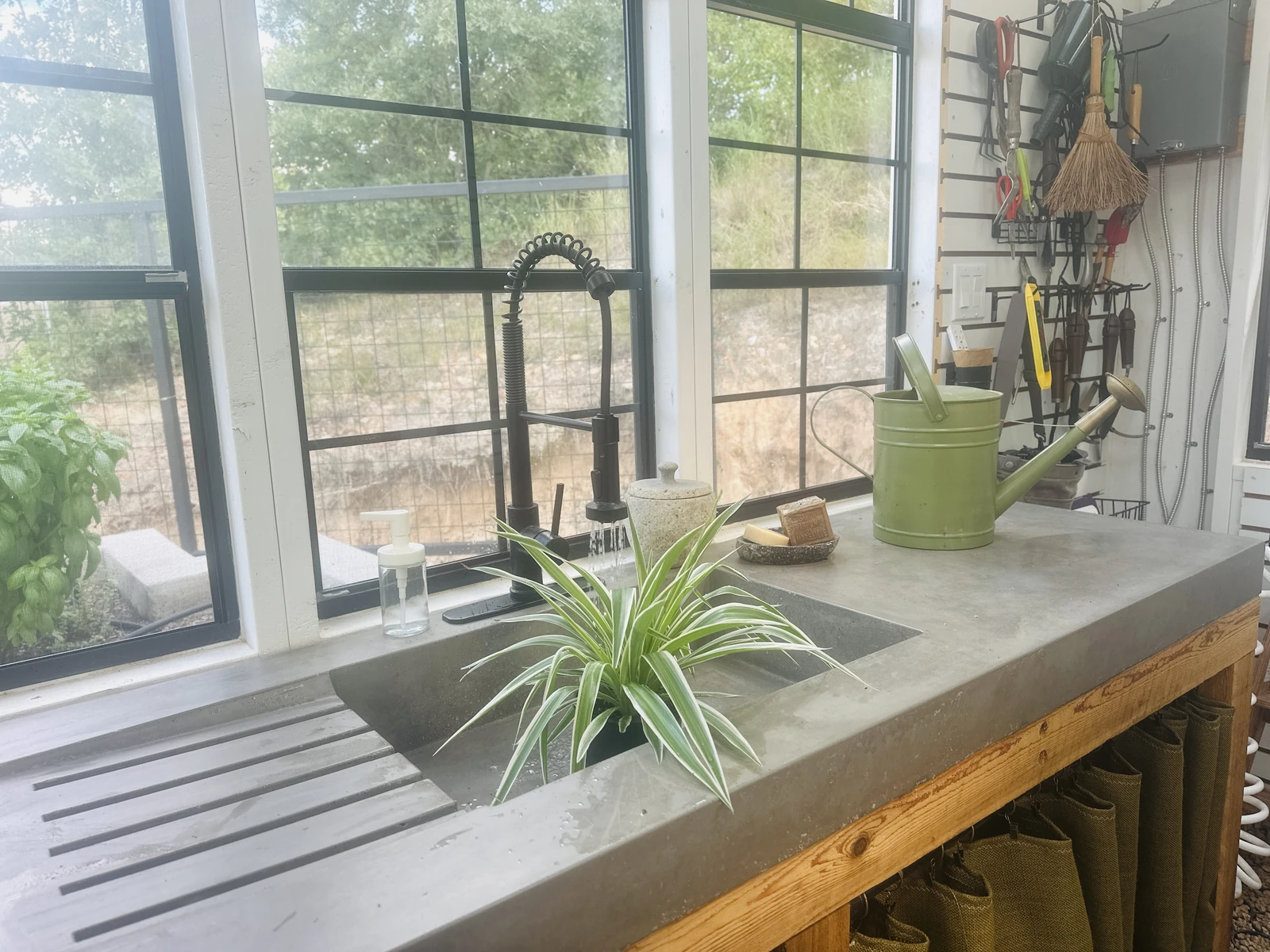 Hand-cast concrete greenhouse sink with integral drainboard on a cedar frame, built by Kennedy's Craft Concrete in Central Texas
