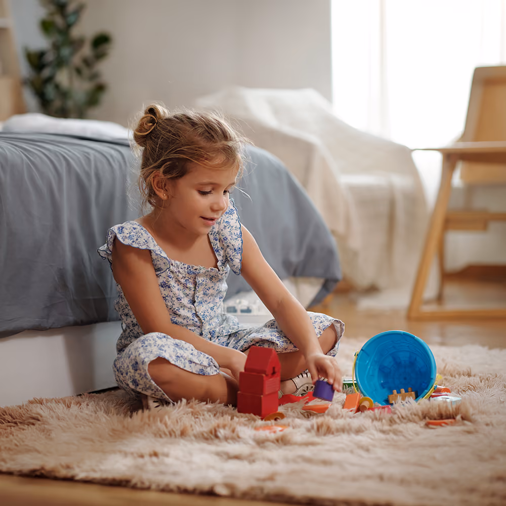 Child playing with toys during a play therapy session in a warm, welcoming therapy office