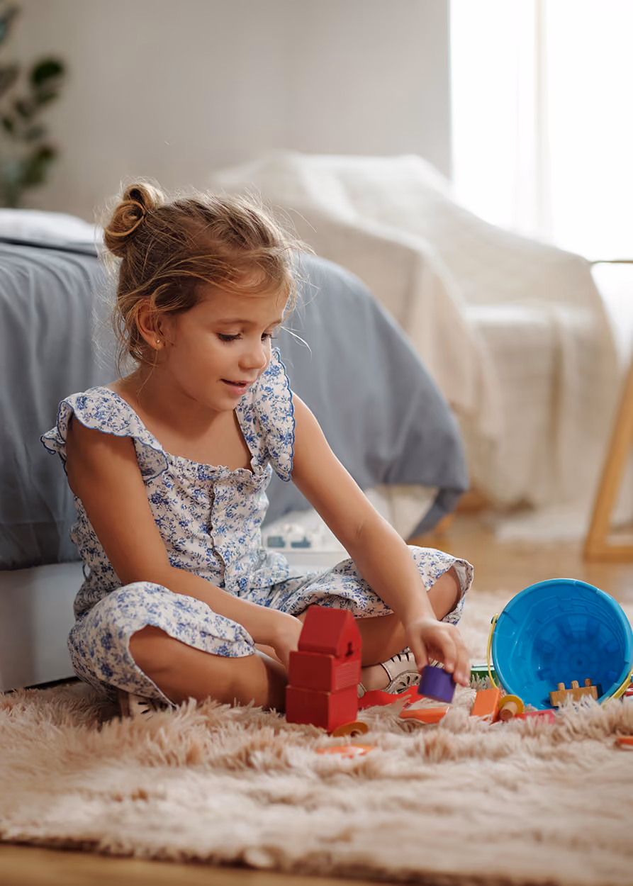 Child playing with toys during a play therapy session in a warm, welcoming therapy office