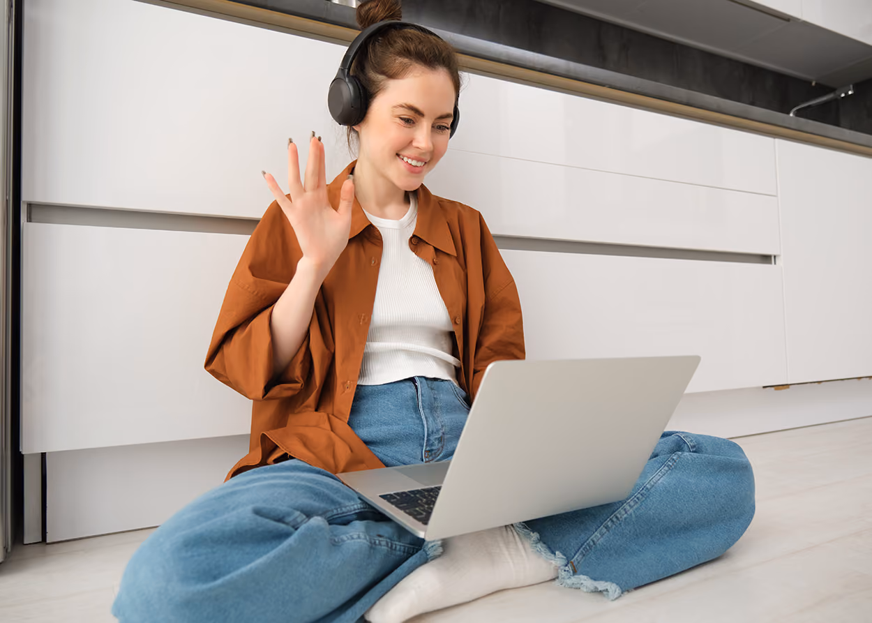 Young adult in an online therapy session on a laptop in a quiet room at home