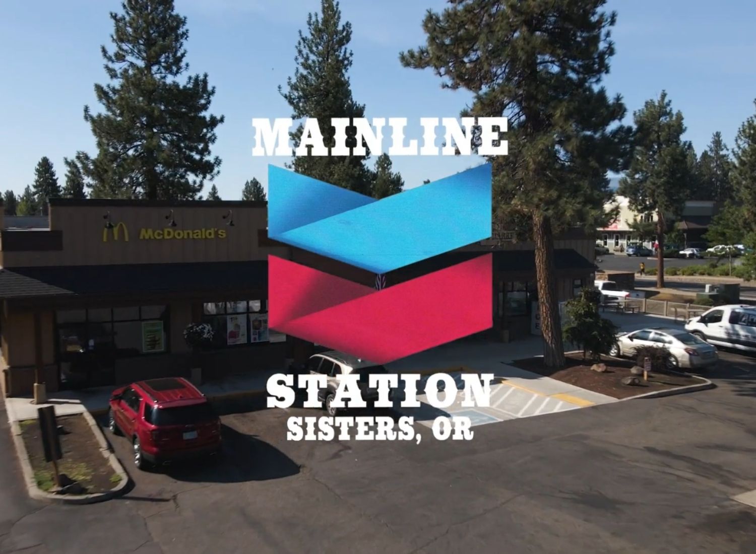 McDonald's restaurant and parking lot with the overlay text 'Mainline Station Sisters, OR' and a blue and red logo.