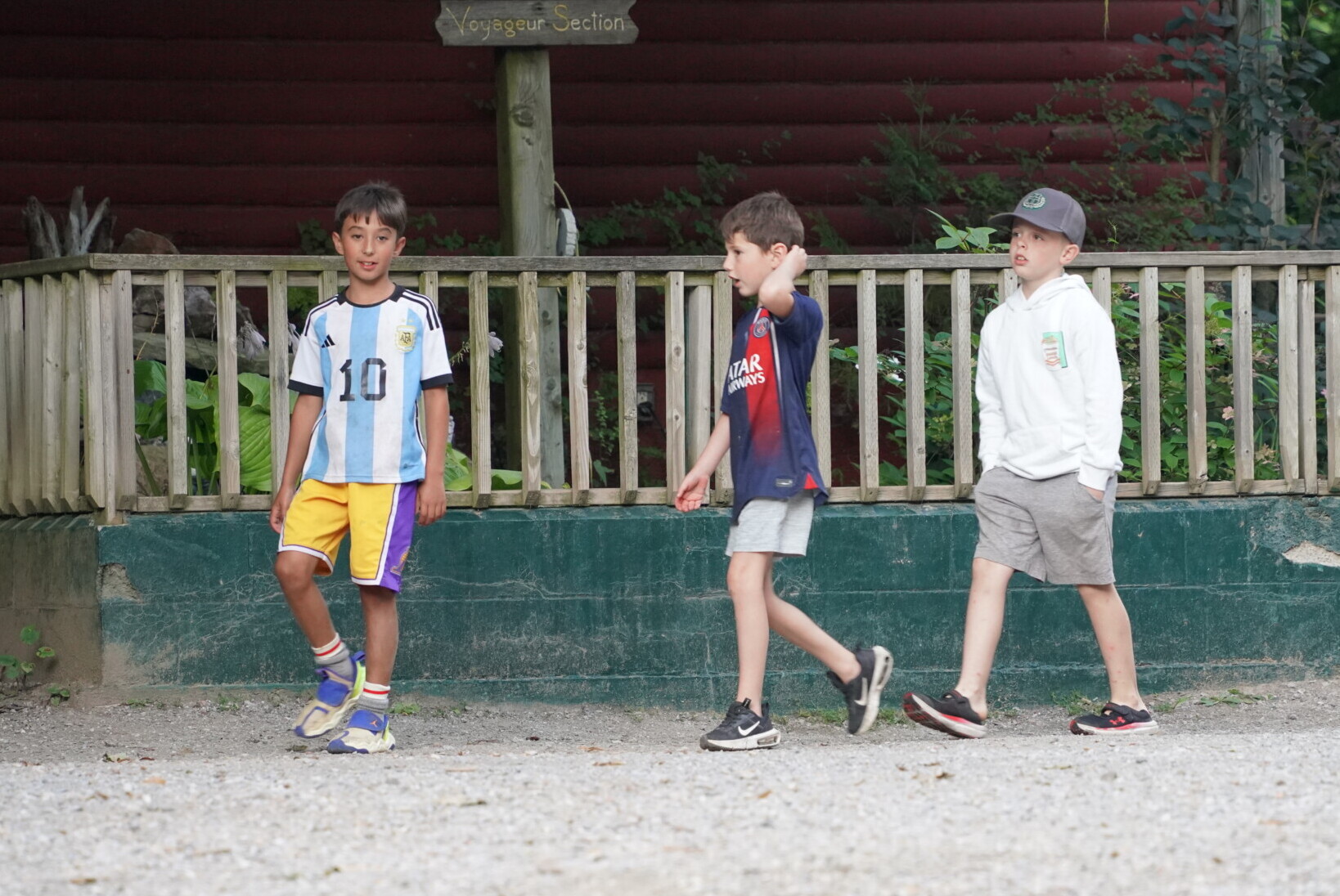 Boys walking past a cabin porch at Kilcoo Camp