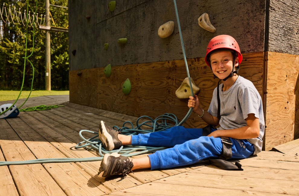 A camper climbing the outdoor rock climbing wall at Kilcoo
