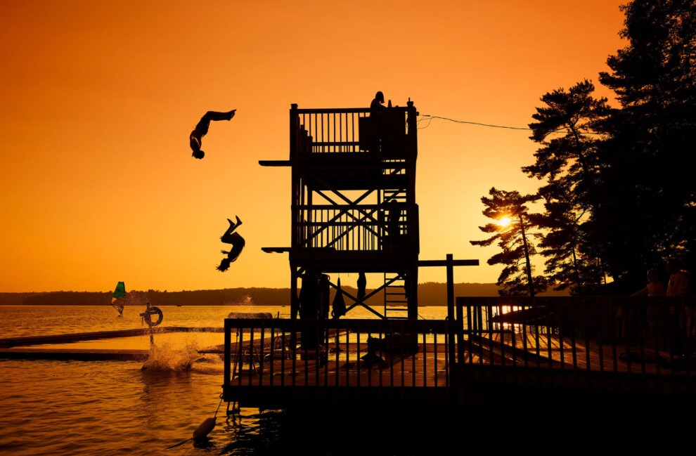 A camper diving off the dock into Gull Lake