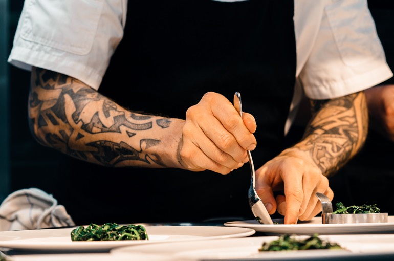 Koch richtet die Teller für das Gänge-Menü an — THE COURT Catering