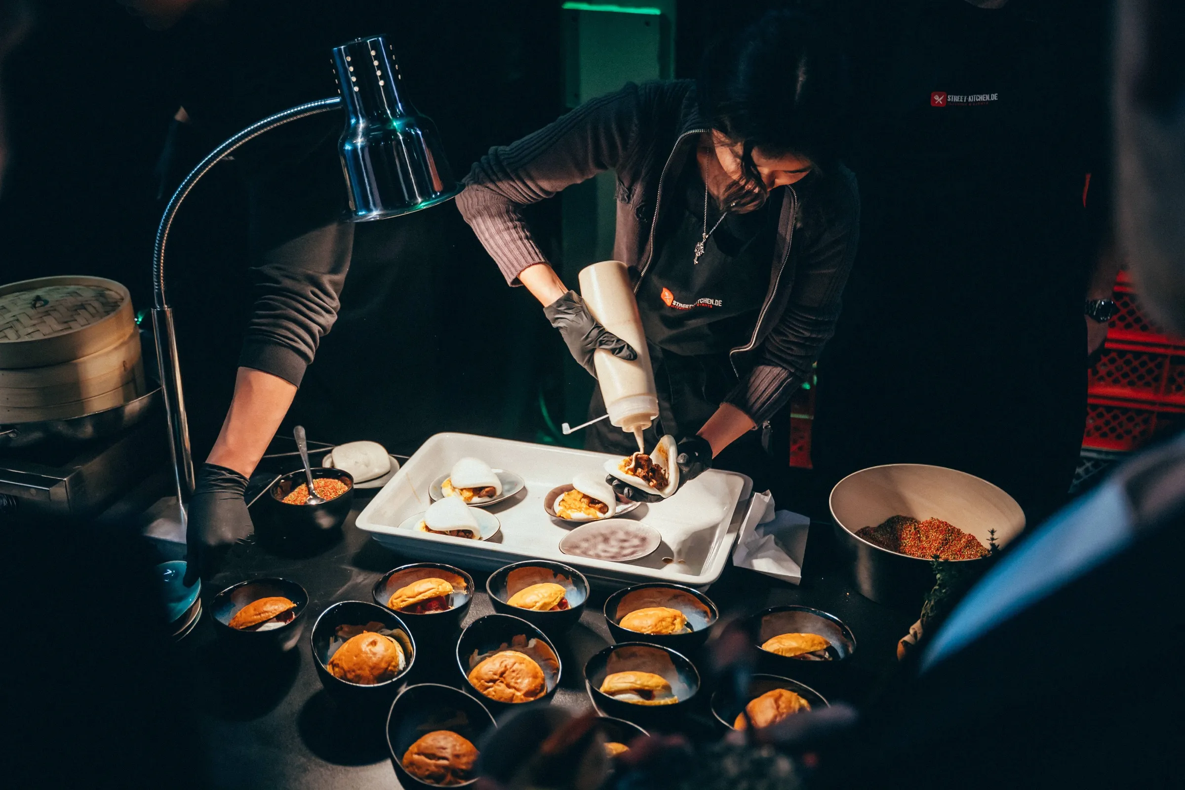 STREET-KITCHEN-Team richtet Bao Buns unter der Wärmelampe an