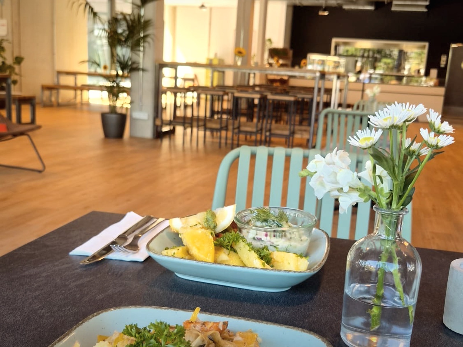 Gedeckter Tisch mit Mittagsgericht und Blumen