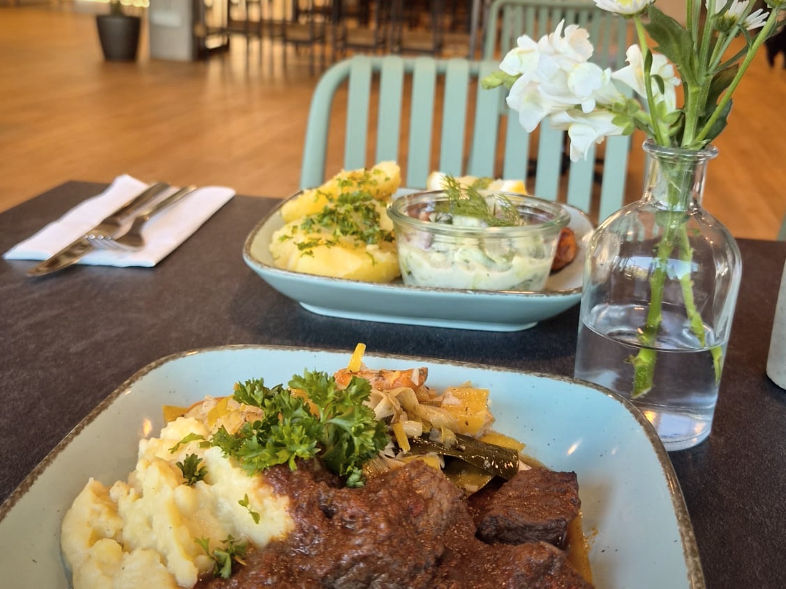 Gedeckter Tisch mit Gericht und Blumen