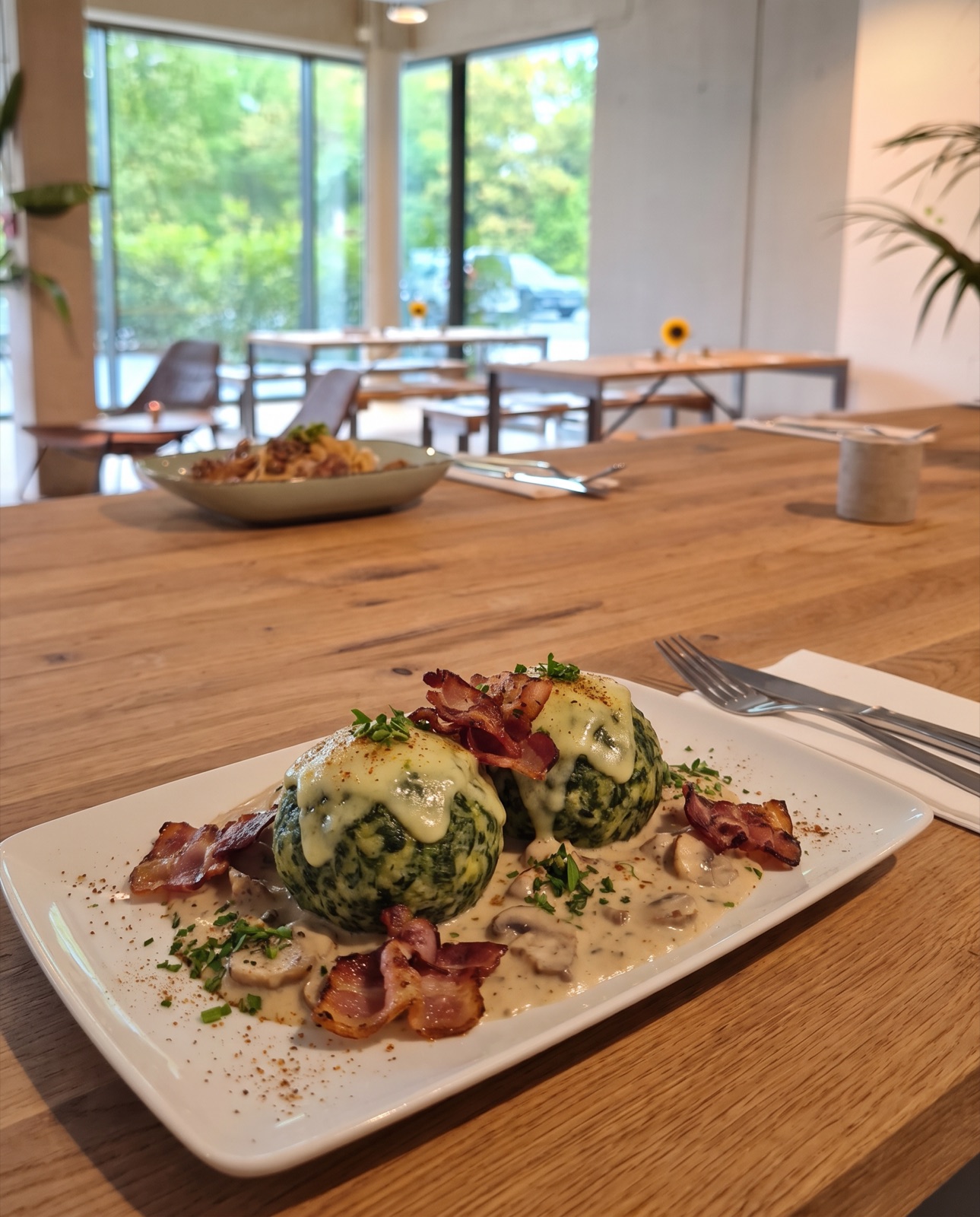 Spinatknödel mit Bergkäse, Champignonrahmsoße und Pancetta