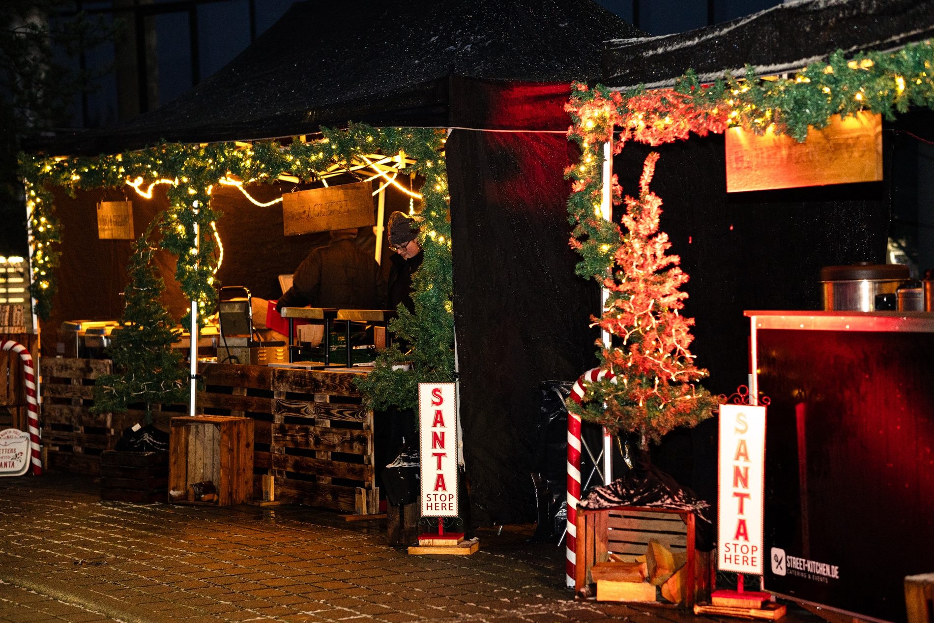 Geschmückte Weihnachtsmarkt-Bude mit Lichterkette und Tanne