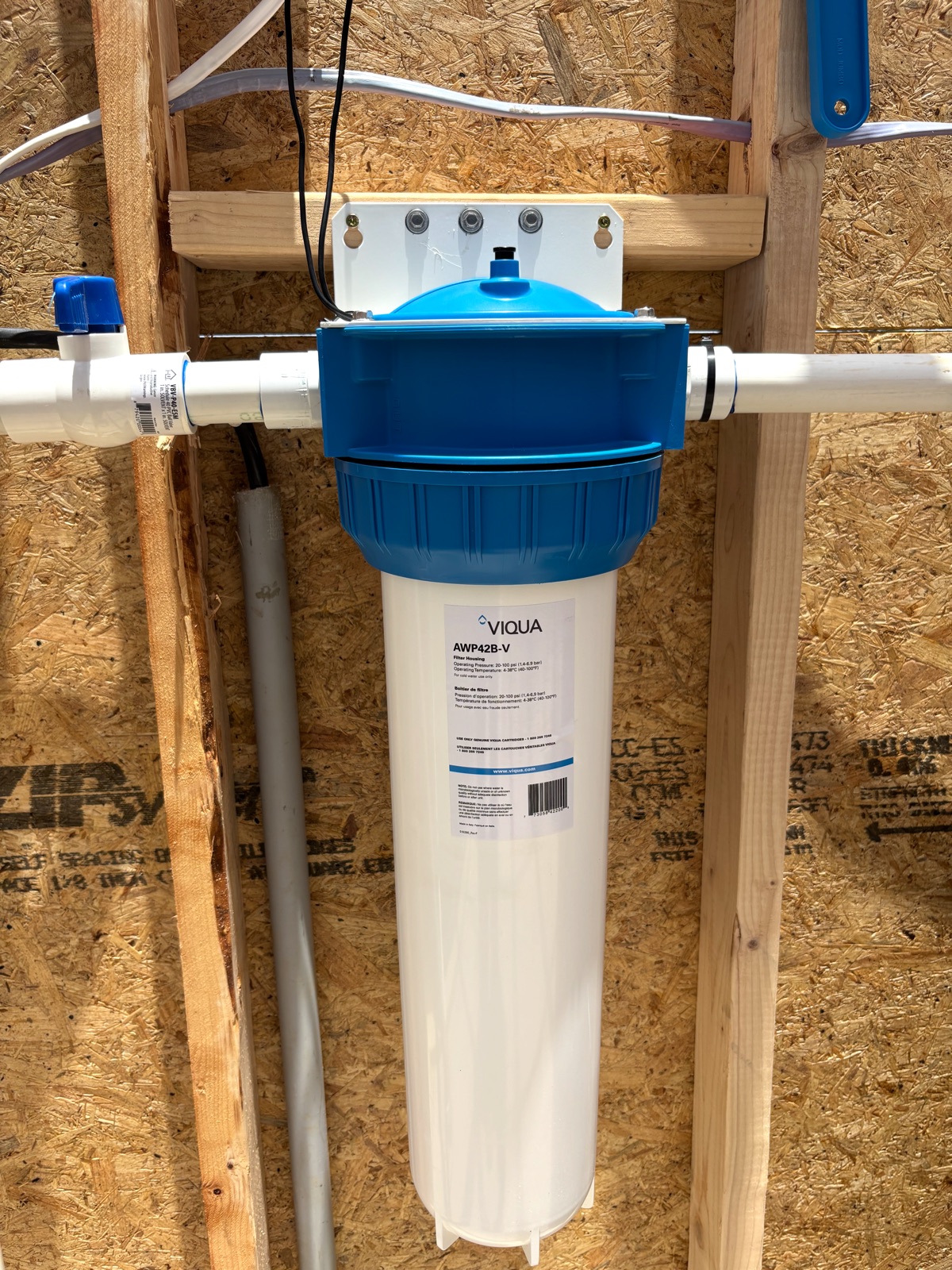 Whole-home water filter housing plumbed into a well line, ready for sediment or carbon filter cartridges