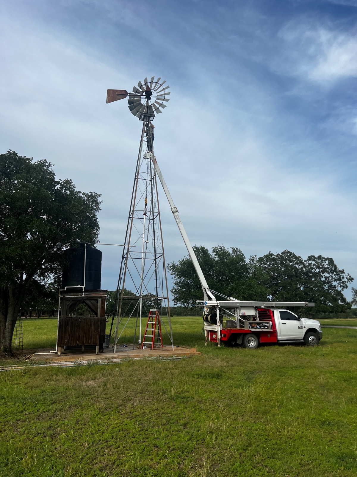 T&A technician servicing a windmill well pump on farmland near Lexington, Texas