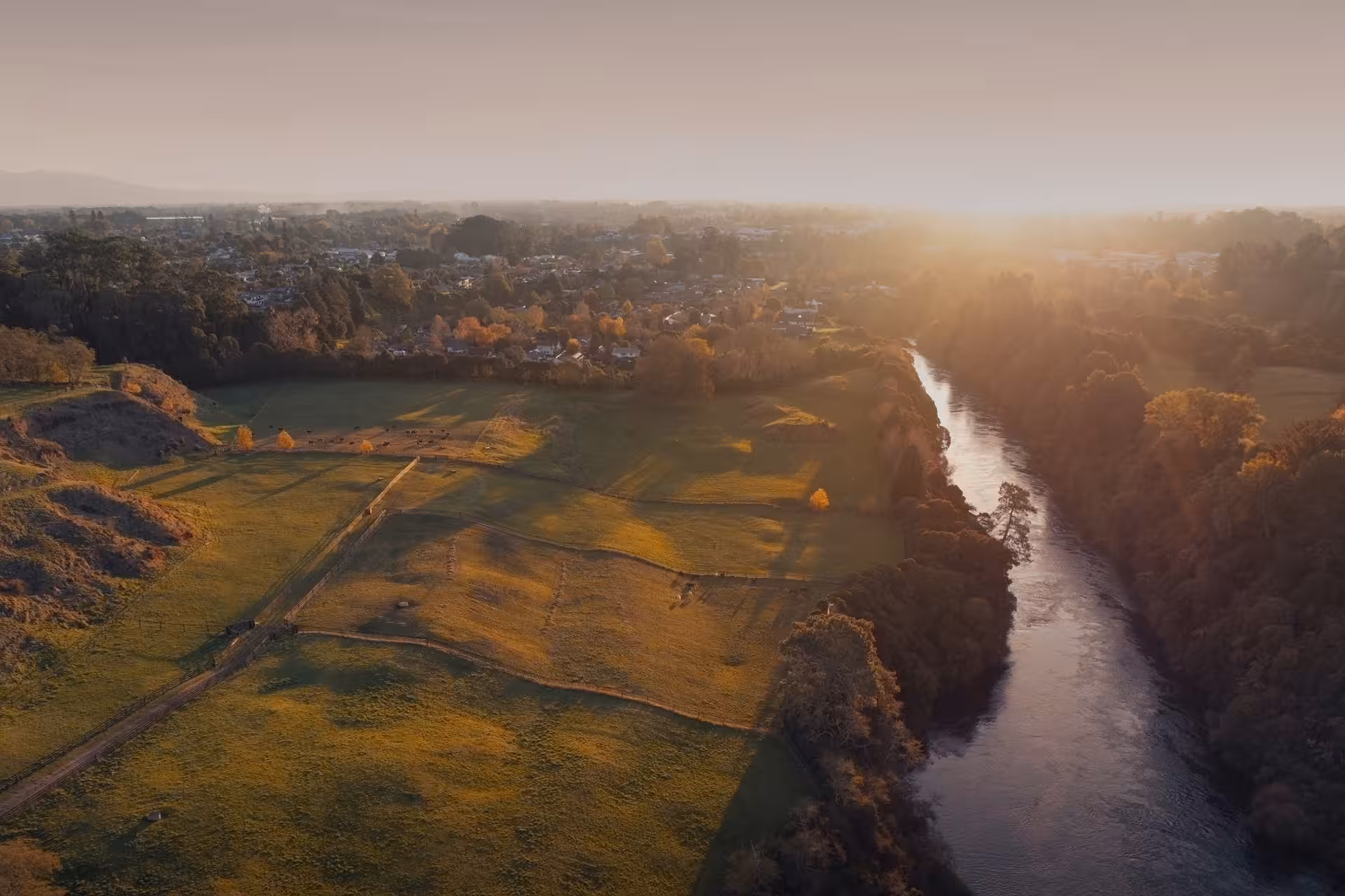 The Waikato River running down the boundary of Rider Park at sunset, with Leamington, Cambridge visible in the distance. 