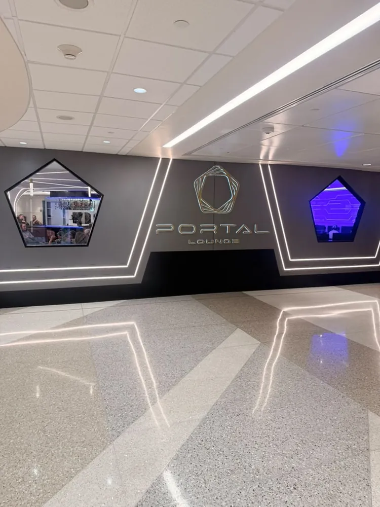 Portal Lounge signage wall at MSP with illuminated pentagon windows looking into the bar and gaming areas