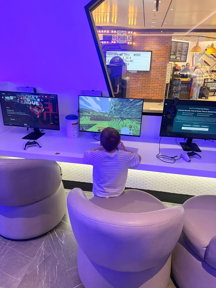 Child playing Minecraft at a console gaming station inside Portal Lounge at MSP Terminal 1