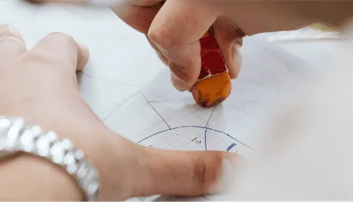 Hand zeichnet geometrische Formen auf Millimeterpapier mit Bleistift-Radiergummi; Detailaufnahme; Fokus auf Präzision.