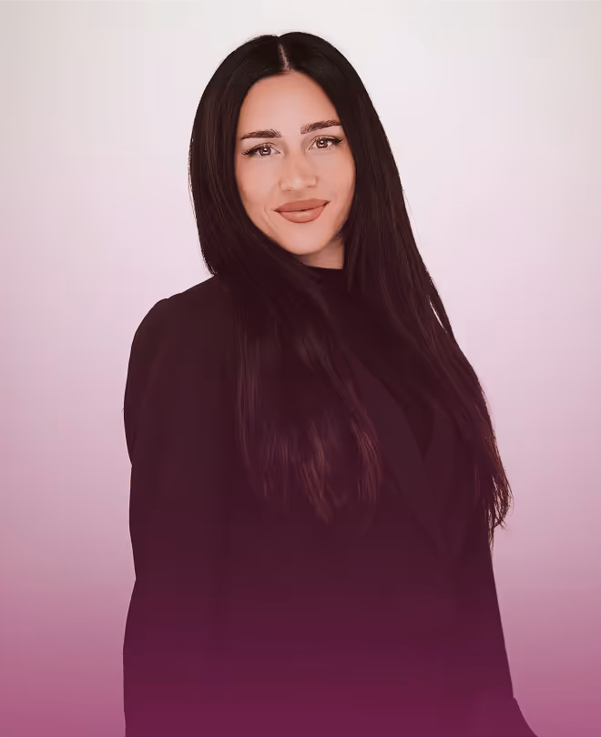Frau mit langen, dunklen Haaren in schwarzem Blazer vor rosa Hintergrund.