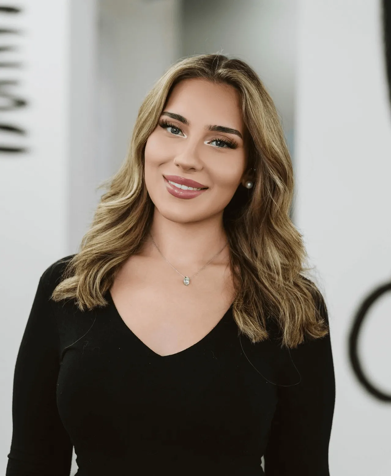 Junge Frau mit gewellten blonden Haaren und dezentem Make-up – Ergebnis einer Make-up-Anwendung