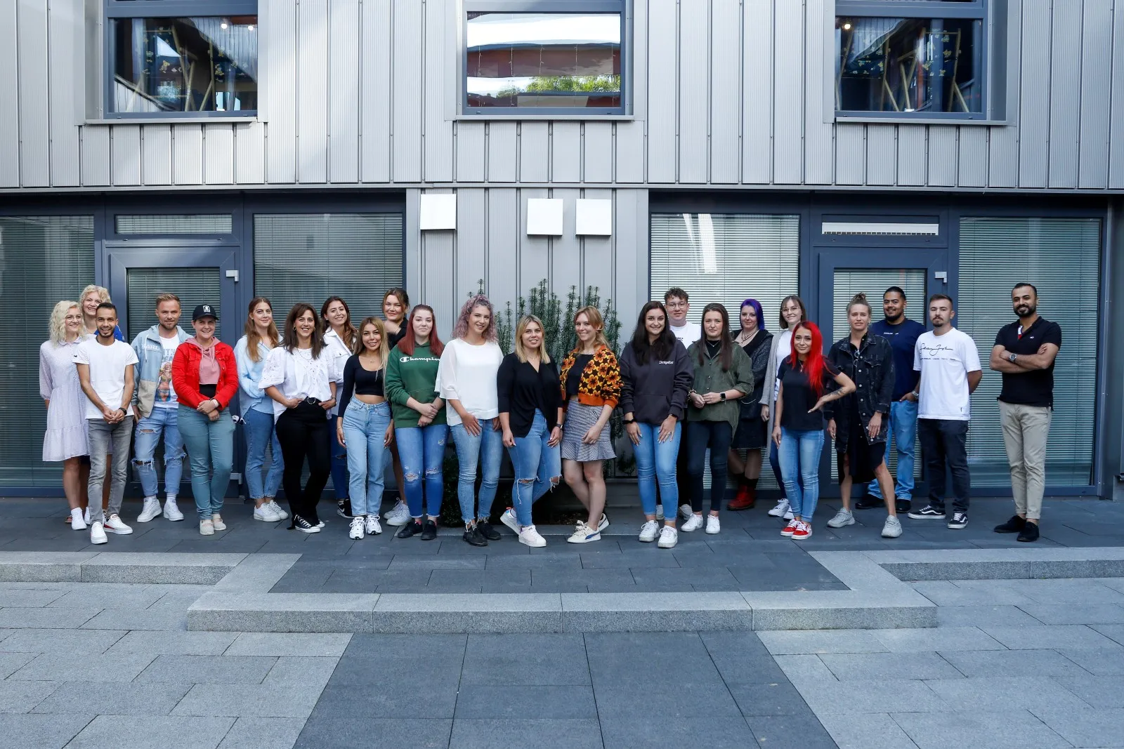 Klassenfoto eines Vollzeit-Meisterkurses vor dem Gebäude der Deutschen Friseurakademie auf dem Campus in Neu-Ulm