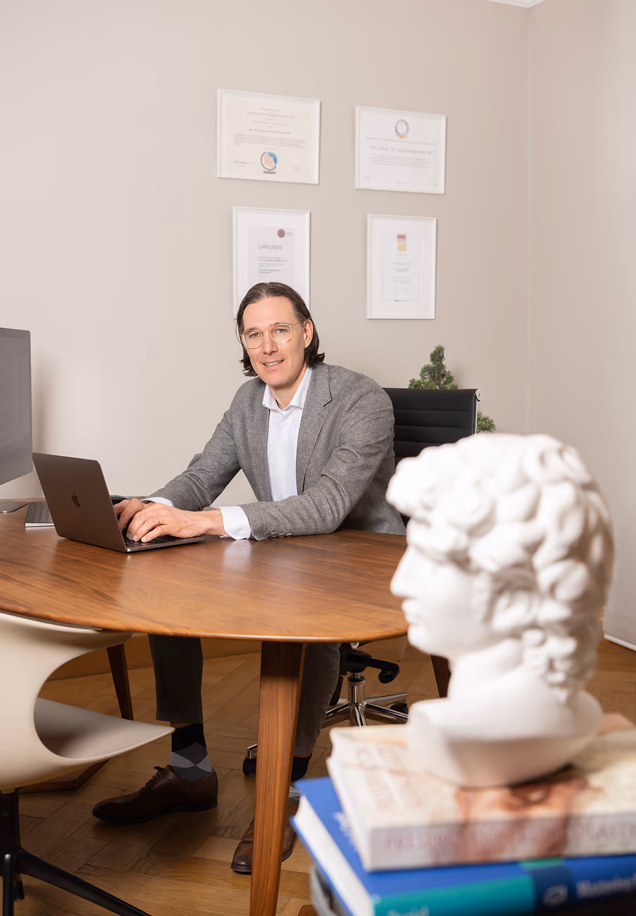 Prof. Dr. med. Johannes A. Veit an seinem Schreibtisch in der Praxis München